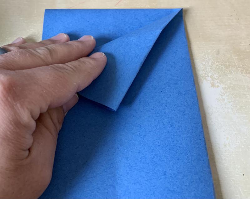 A hand performs the fold just described.
